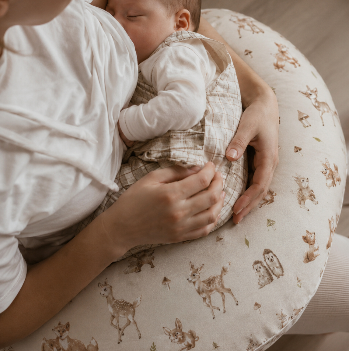 Mamma ammar nyfött barn med stöd av amningskudde Skogens Vänner från ZUZU Studio