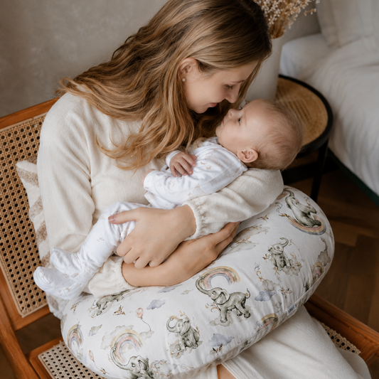 Förälder matar nyfödd baby med flaska med amningskudde från ZUZU Studio – ergonomiskt stöd som avlastar nacke, axlar och rygg vid matning